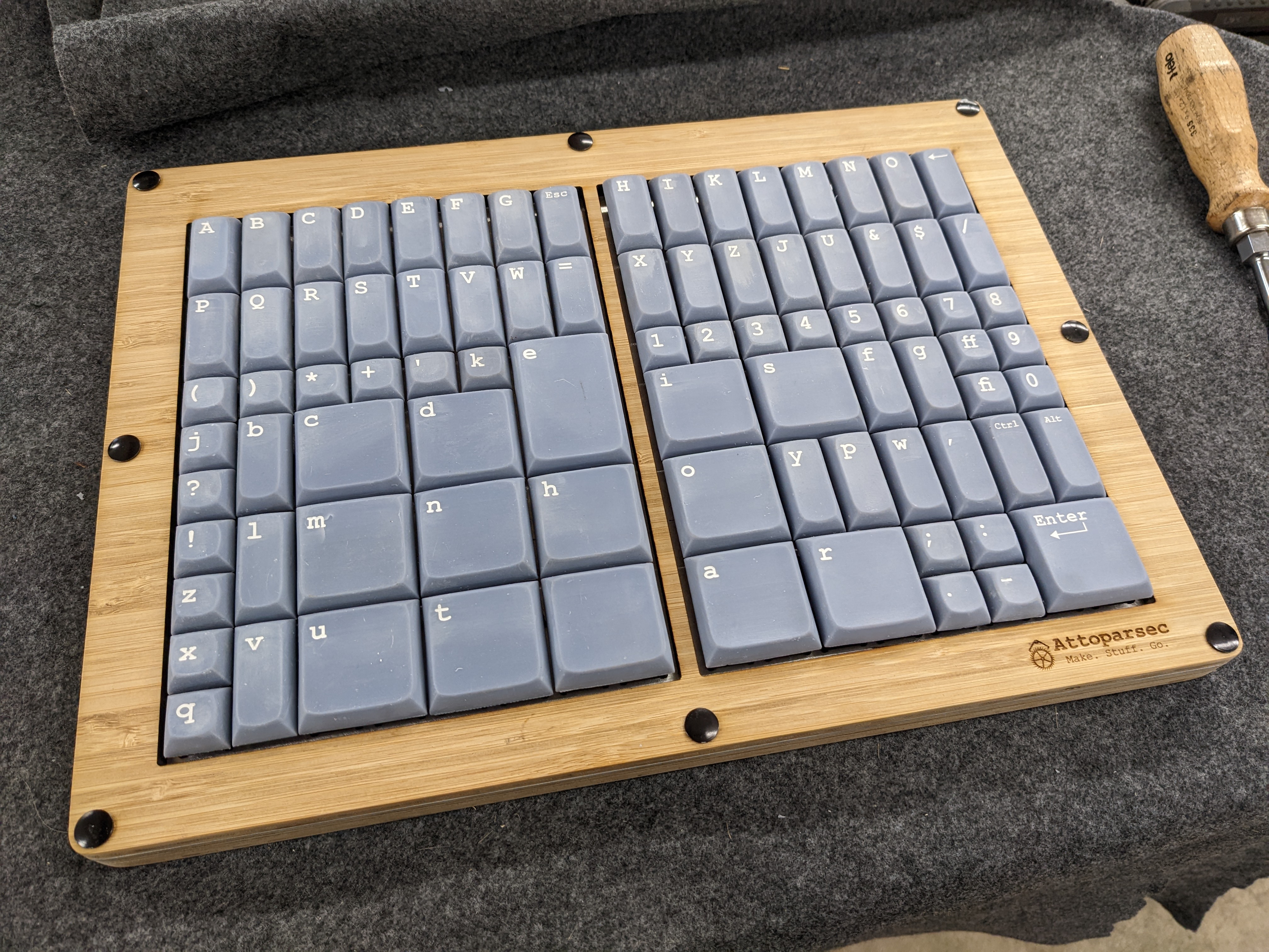 A keyboard built in a laser-cut wood enclosure. It is much more square in aspect ration than a normal keyboard, and not all the keys are the same size.